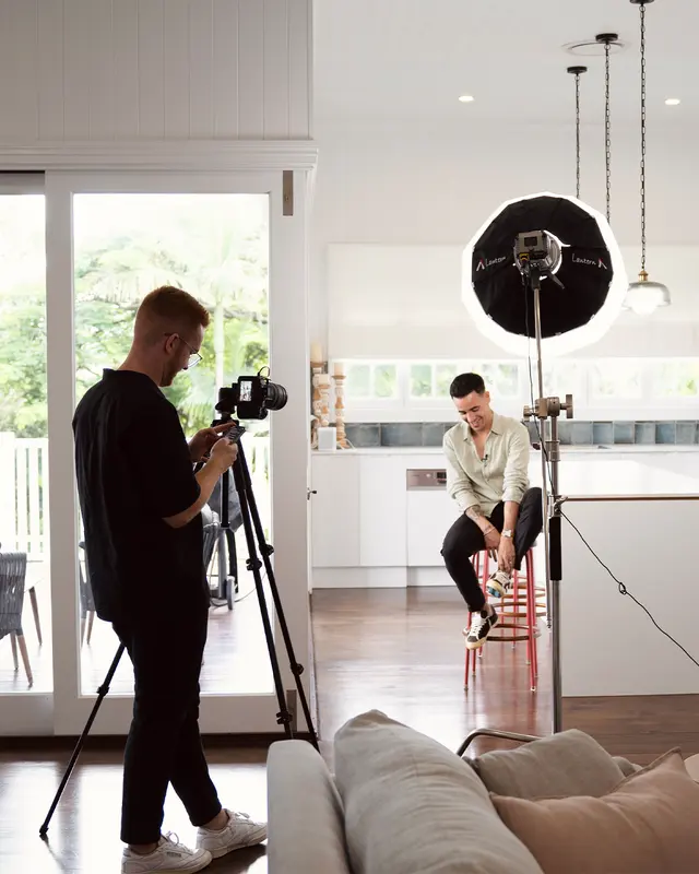 Jethro Staggs setting up a camera and lighting in a client's home for a shoot day.